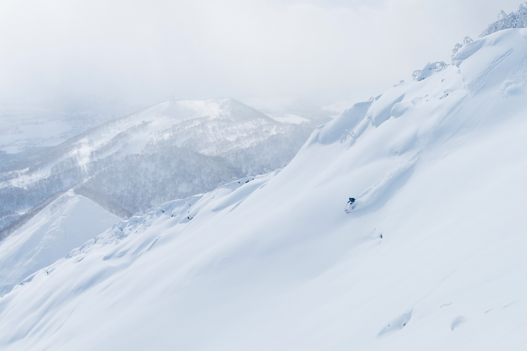 Skier riding deep powder on a Hokkaido mountain